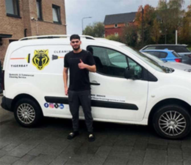 Worker standing next to van with Tiger Bay cleaning logo